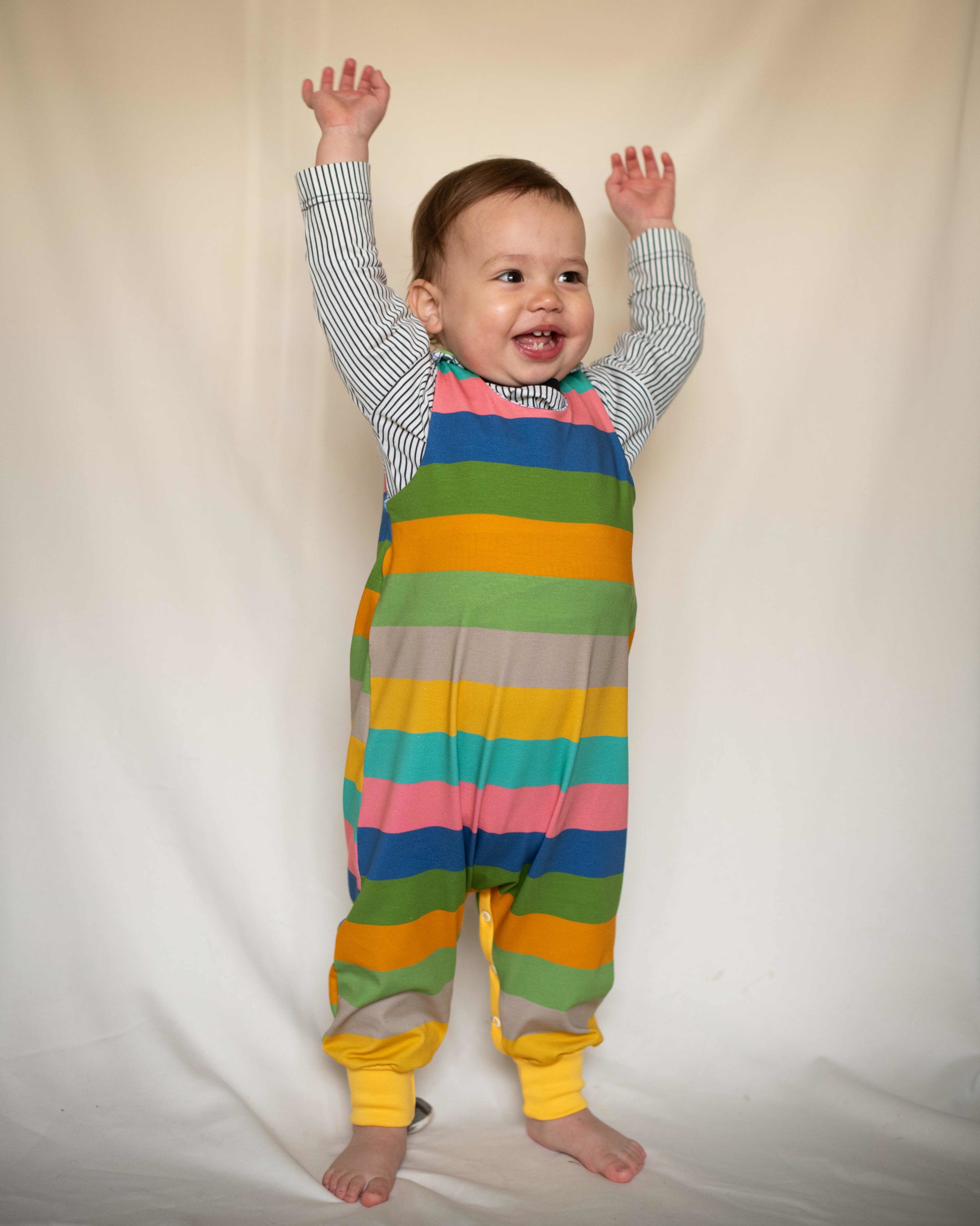 Child wearing Rainbow Stripes Organic Romper