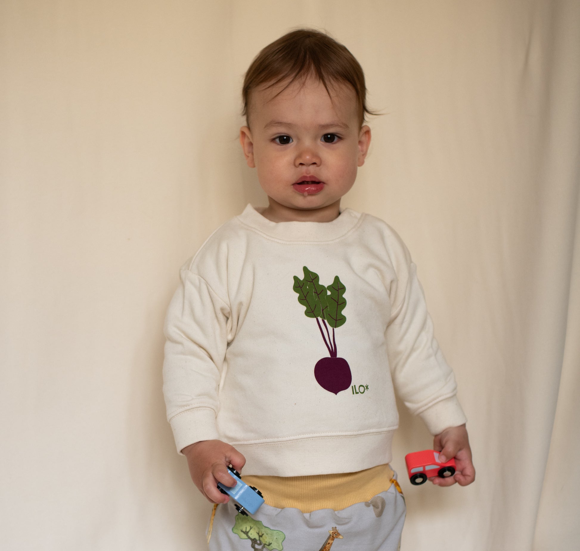 Child wearing the organic cotton screen printed sweater with a beetroot